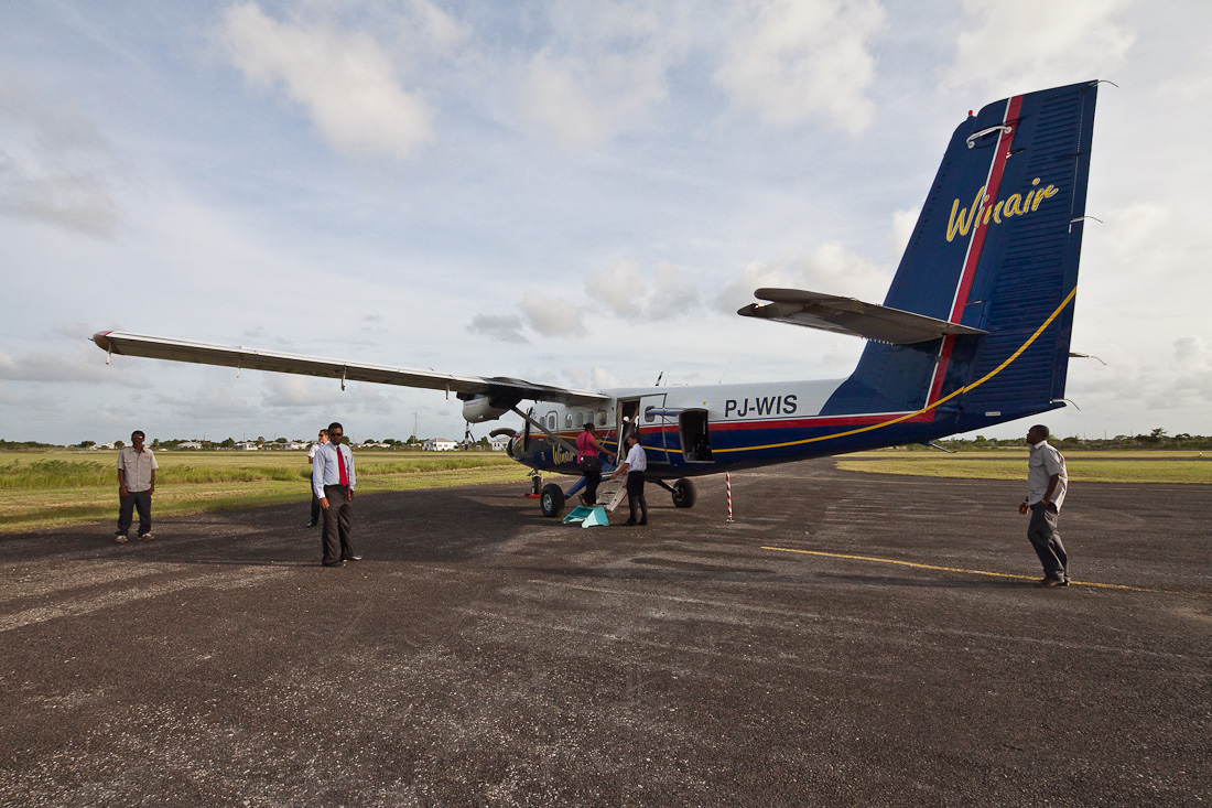 Аэропорт Барбуда Кодрингтон, остров Барбуда, Антигуа и Барбуда. Винтовой самолёт на перроне аэропота. Barbuda Codrington Airport (IATA: BBQ), Barbuda island, Antigua and Barbuda, Caribbean. PJ-WIS, DHC-6-300, de Havilland Canada DHC-6 Twin Otter on the apron