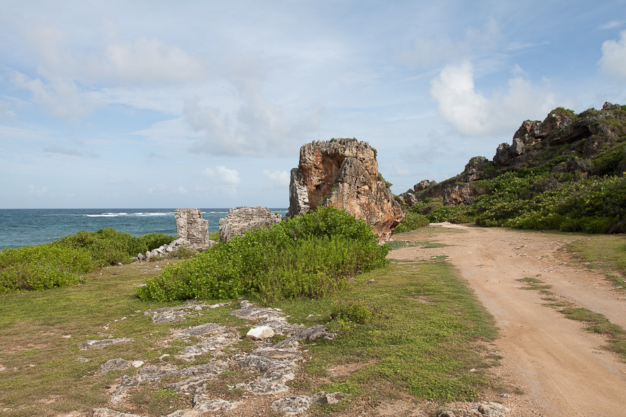 Конец грунтовой дороги вокруг острова Барбуда и коралловые утёсы, Антигуа и Барбуда. The end of a dirt road around the island of Barbuda and coral cliffs, Antigua and Barbuda, Caribbean.