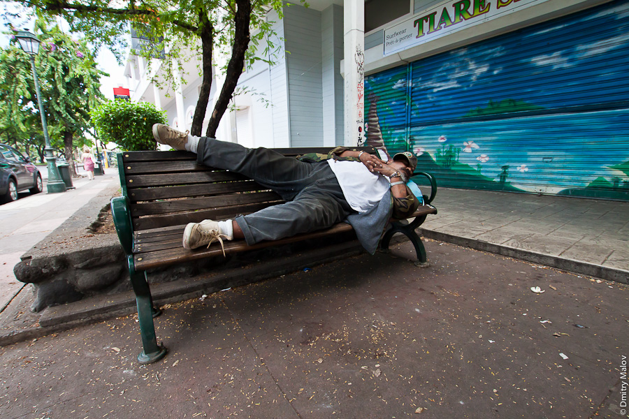 A man sleeping on street of Papeete, Tahiti, French Polynesia. Мужчина спит на улице в городе Папеэте, Таити, Французская Полинезия.
