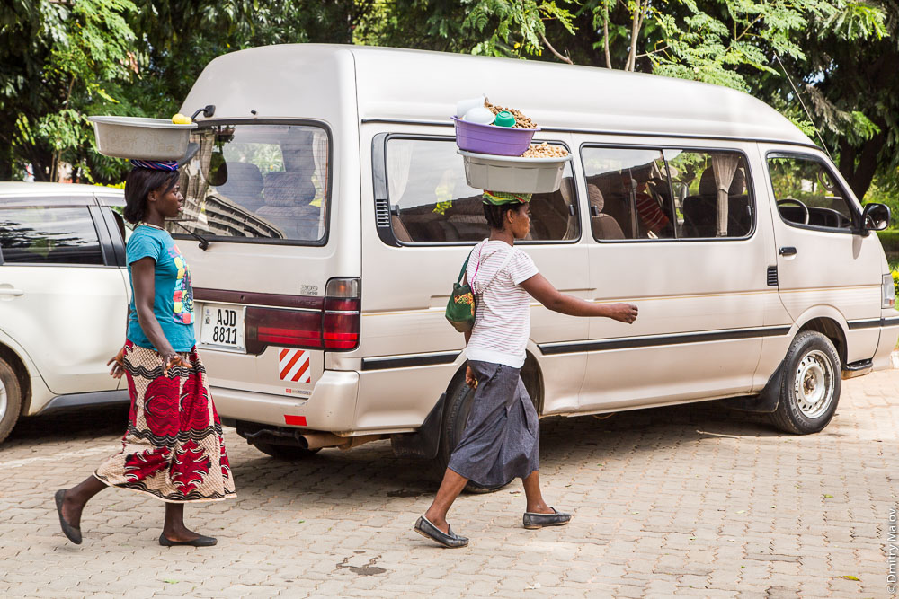 Women with a load on their heads. Livingstone downtown, Zambia, city centre, on the main street. Город Ливингстон, Замбия. Центр, женщины с грузом на голове на центральной улице. AJD8811