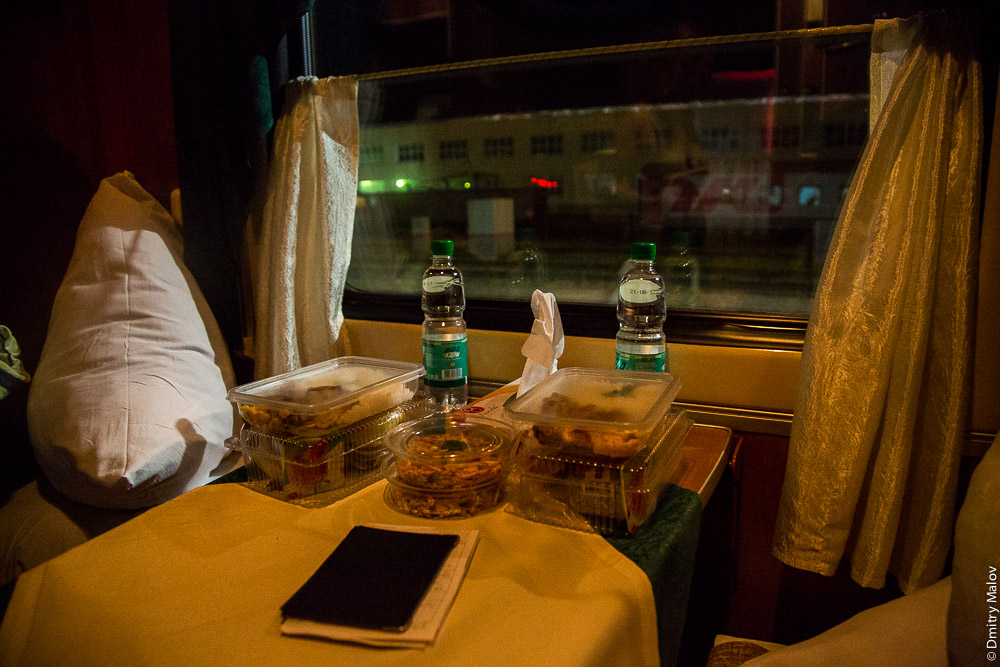 Внутри купе, столик, вода, еда. Ночной поезд №1 Южно-Сахалинск — Ноглики. Express train 1 Yuzno-Sakhalinsk — Nogliki, Sakhalin, Russia. Inside the compartment, table, water, food.