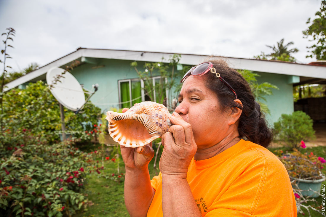 Женщина дует в полинезийский горн пу из раковины. Риматара, архипелаг Острал (Тубуаи), Французская Полинезия. Woman blowing a conch shell pū, Rimatara, the Austral archipelago (Tubuai), French Polynesia.