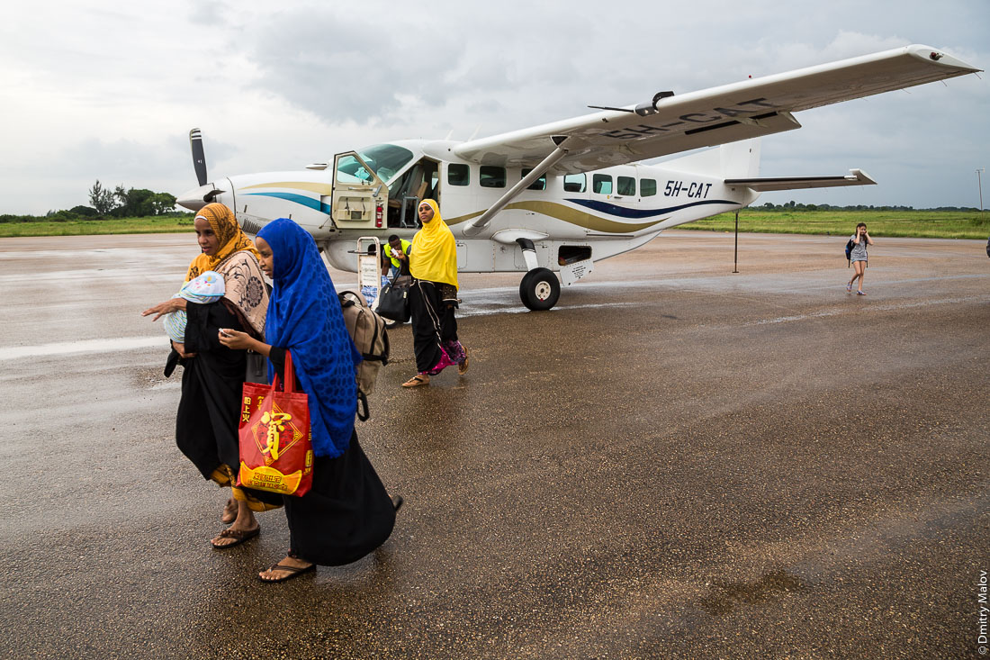 Пассажиры на перроне аэропорта Пембы (PMA), остров Пемба, Занзибар, Танзания. Local Passengers — 3 ladies in abaya and islamic clothing, on apron of Pemba Airport (PMA), Cessna Caravan 208 B (5H-CAR), Pemba island, Zanzibar, Tanzania.