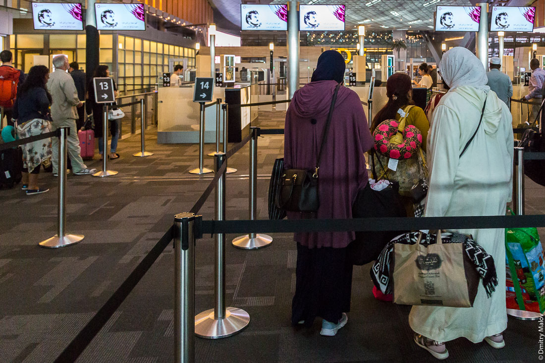 Tamim Al Majd graphic logo on displays in border control zone in international airport of Doha (Hamad International Airport. IATA: DOH, Qatar). Портрет шейха Тамим бин Хамад Аль Тани на экранах в зоне пограничного контроля международного аэрпортора Дохи, Катар.