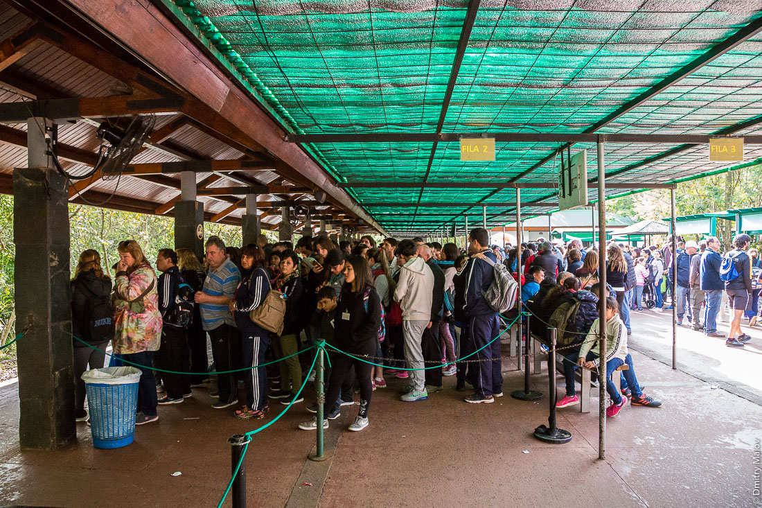 Tourists in Iguazu waterfalls national park are waiting for a train at Cataratas station, Argentina. Туристы в национальном парке водопадов Игуасу ждут поезда на станции Катаратас, Аргентина.
