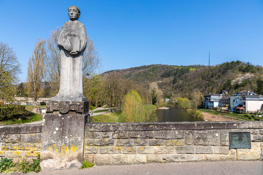 Мост из Эхтернаха в Эхтернахербрюк, фигура святого. Медная табличка обозначает границу Люксембурга и Германии. Bridge from Echternach to Echternacherbruck, a figure of a Saint. A copper plate marks the border of Luxembourg and Germany.