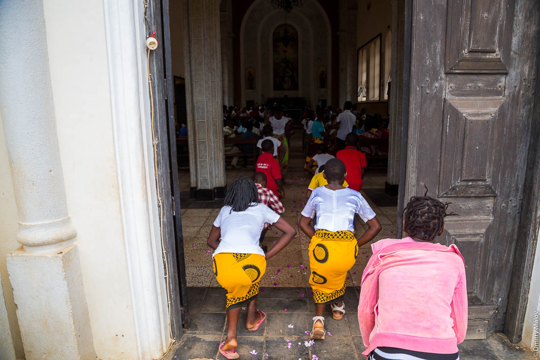 Воскресная месса. Чёрные девушки в жёлтых юбках танцуют в католическом храме, Santuário de S. M. Mãe do Redentor, Meconta, Mozambique.