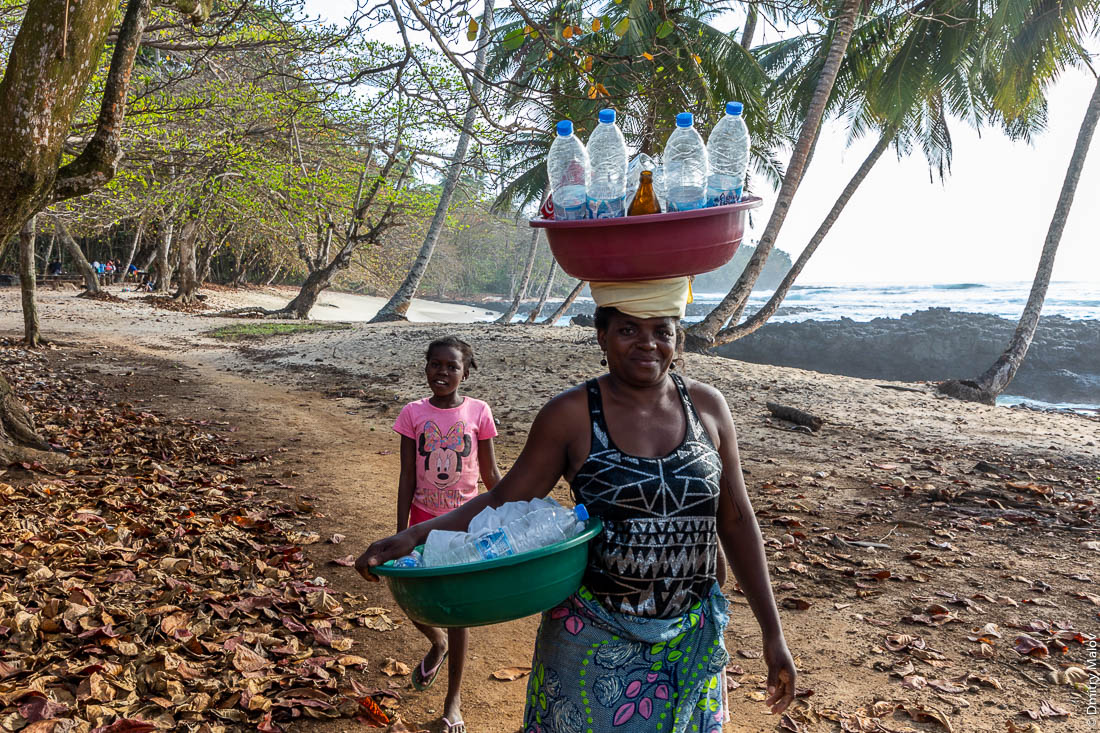 Женщина несет в тазу груз пустых пластиковых бутылок на голове, остров Ролаш, Сан-Томе и Принсипи, Африка