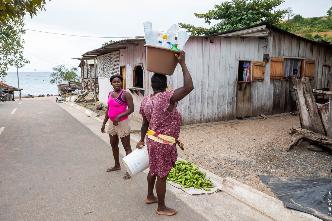 Женщина несет в тазу на голове груз пустых пластиковых бутылок, Сан-Томе и Принсипи, Африка